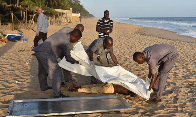 People put a blanket on a body lying on the beach  following  after gunmen went on a shooting rampage in the Ivory Coast resort of Grand-Bassam,  on March 13, 2016. 
Fourteen civilians and two soldiers were killed in the attack, President Alassane Ouattara said. / AFP PHOTO / SIA-KAMBOUSIA-KAMBOU/AFP/Getty Images