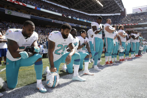 From left, Miami Dolphins' Jelani Jenkins, Arian Foster, Michael Thomas, and Kenny Stills, kneel during the singing of the national anthem before an NFL football game against the Seattle Seahawks.