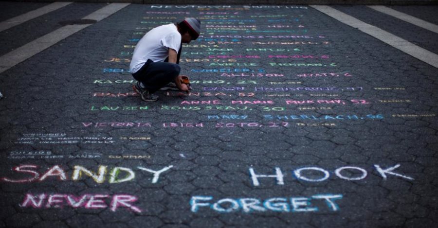 FILE PHOTO:    Street artist Mark Panzarino, 41, prepares a memorial as he writes the names of the Sandy Hook Elementary School victims during the six-month anniversary of the massacre, at Union Square in New York, June 14, 2013.  REUTERS/Eduardo Munoz/File Photo