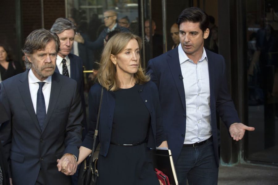 Felicity Huffman leaves Boston courtroom alongside her husband (left).