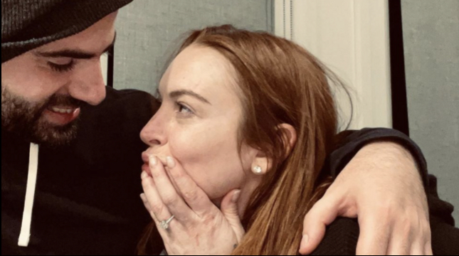 Lindsay Lohan and Bader Shammas cuddling while she shows off her engagement ring. This is one of the photos she posted on Instagram.