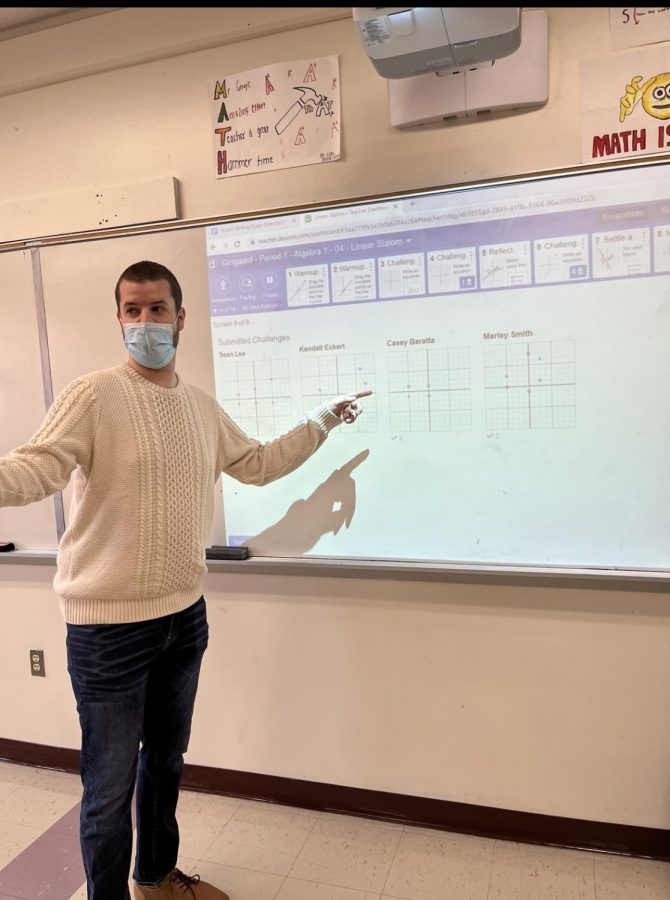 Photo of Mr. Grogaard pointing at white board