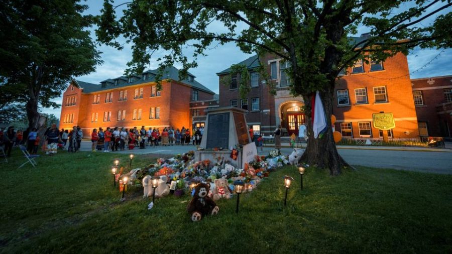 Kamloops residents and First Nations people gather  at a memorial in front of the former Kamloops Indian Residential School after the remains of 215 children were found at the site. 