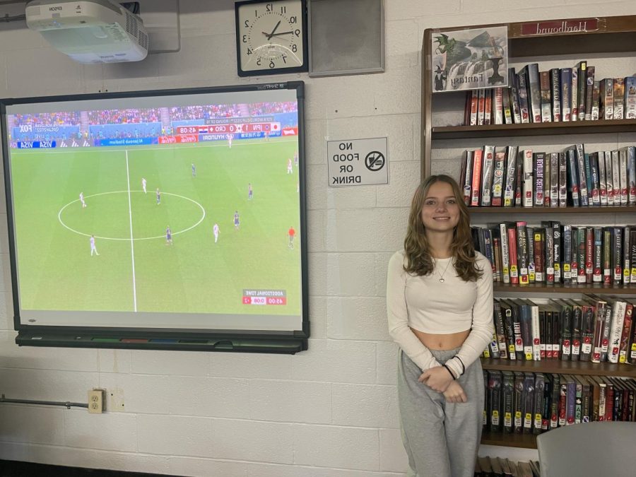 student stands in front of world cup showing
