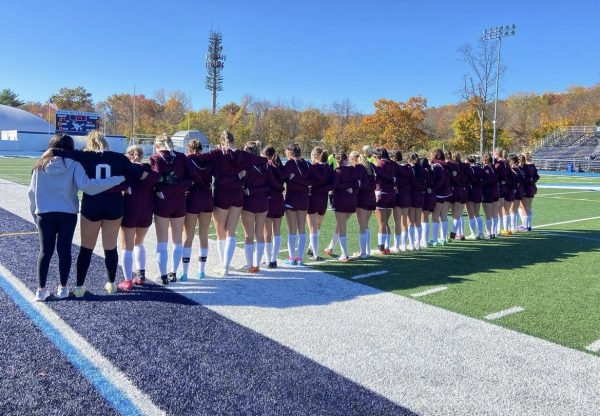 The Wayne Hills Girls Soccer team gathers together on the field.